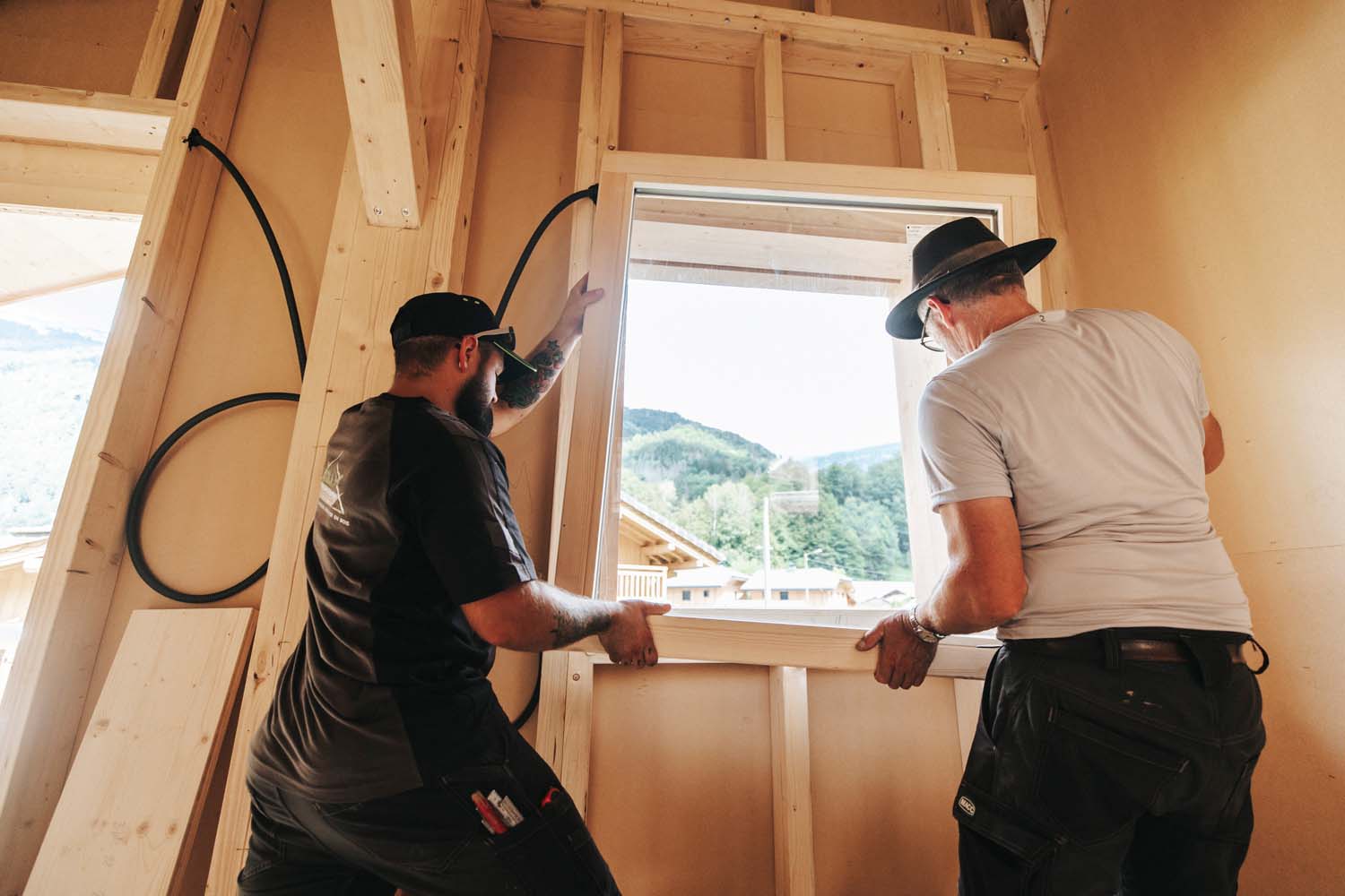 Photo de deux artisans en plein chantier d'aménagement intérieur et extérieur d'un chalet