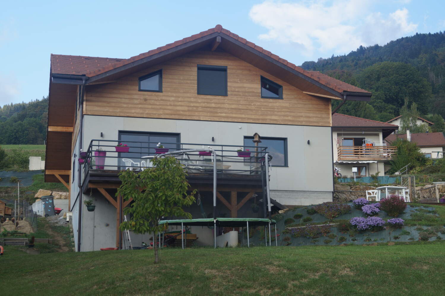 Vue extérieure depuis le jardin sur une constuction de chalet à Viuz-en-Sallaz